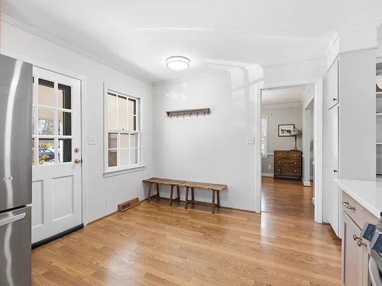 Mudroom with painted wood paneling, door and window trim